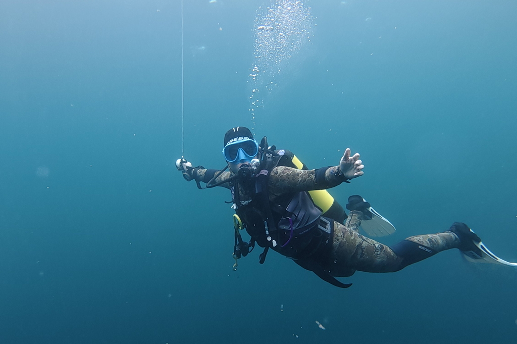 happy scuba diver underwater waiting during safety stop in clear Atlantic waters around aran islands