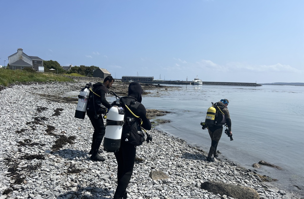 Scuba divers on the way to do shore dive near dive aran