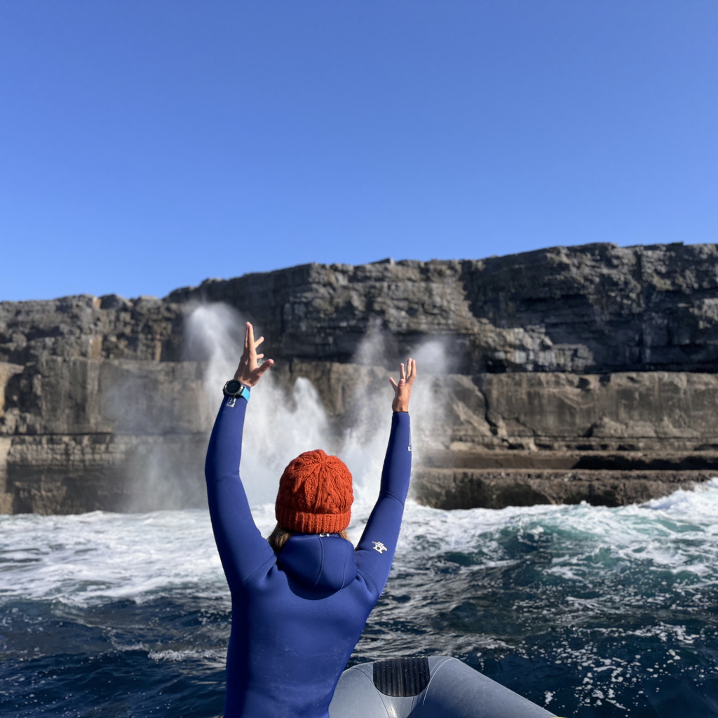 Freediver on the boat watching amazing Inishmore coastline, Aran Islands