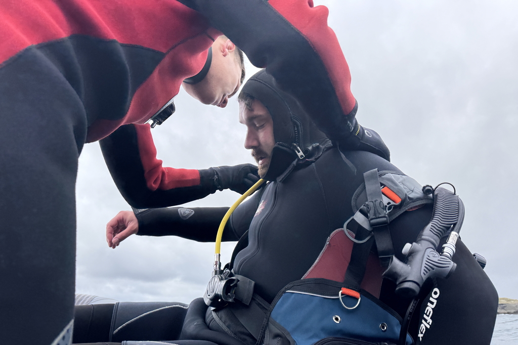 two divers helping each other on the boat after scuba in Atlantic around aran islands